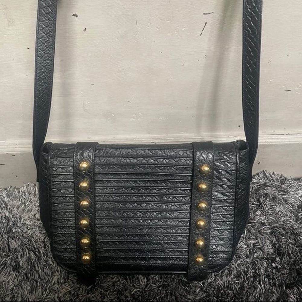 This is a designer handbag by silvano biagini black bag with gold features.